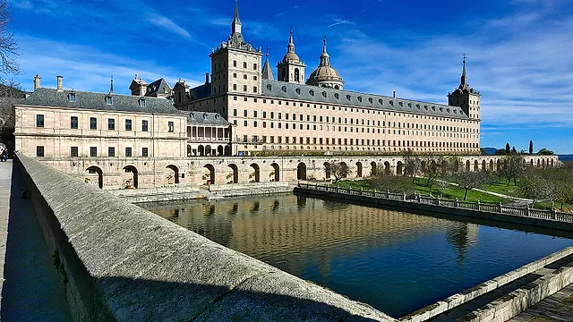 The south front of the Royal Monastery of El Escorial, with its long wall and a pond in front