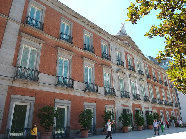 The side of the Thyssen-Bornemisza Museum with its rows of windows and a tree in front