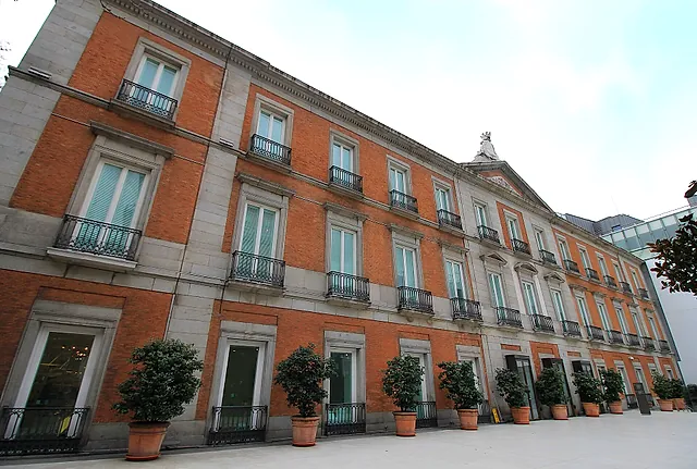 A side of the Thyssen-Bornemisza Museum with potted plants along the wall